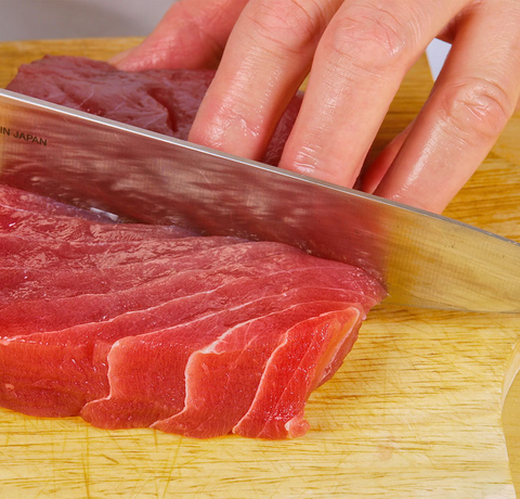 Szef kuchni przygotowuje rybę do sushi